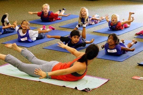 Yoga teacher Jackie Bergeron works with students at Paul Ecke Central Elementary School last week in Encinitas. Students attend two 40-minute yoga classes each week. Eduardo Contreras • U-T